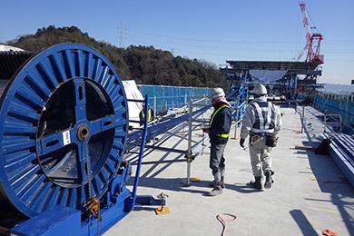 Roll on the drum of PC steel is inserted to the bridge (photo: sumitomo mitsui construction (strains))