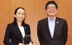 Ms. Kunii with her plaque and souvenir brooch